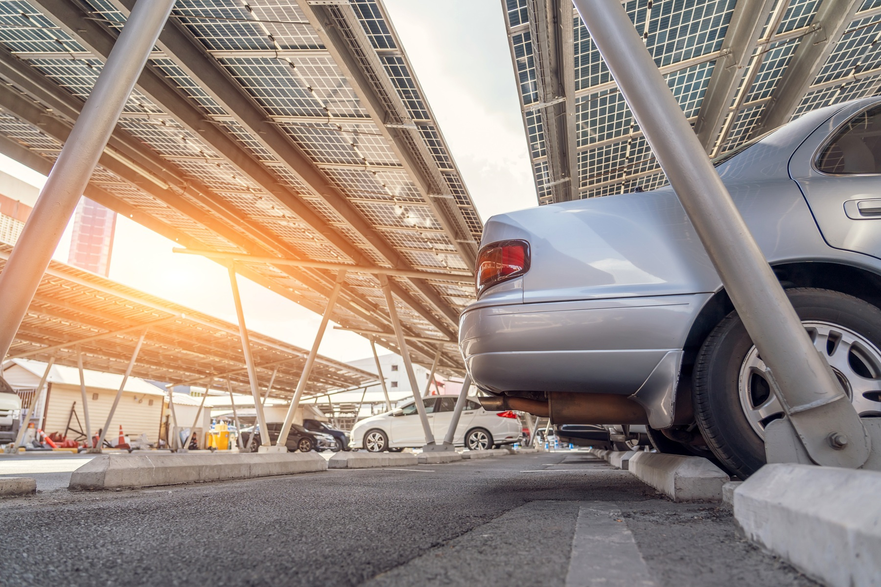 Carport fotowoltaiczny nad parkingiem firmowym z panelami słonecznymi na dachu wiaty