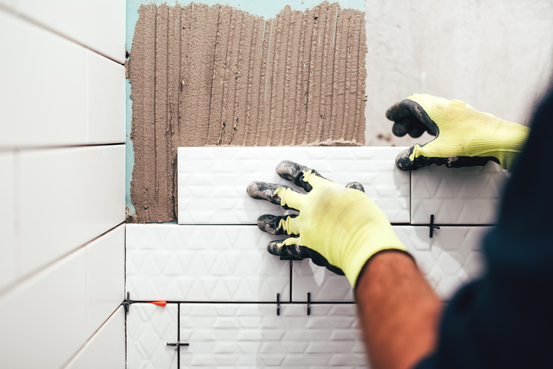 ekipa remontowa przy układaniu płytek ceramicznych w łazience