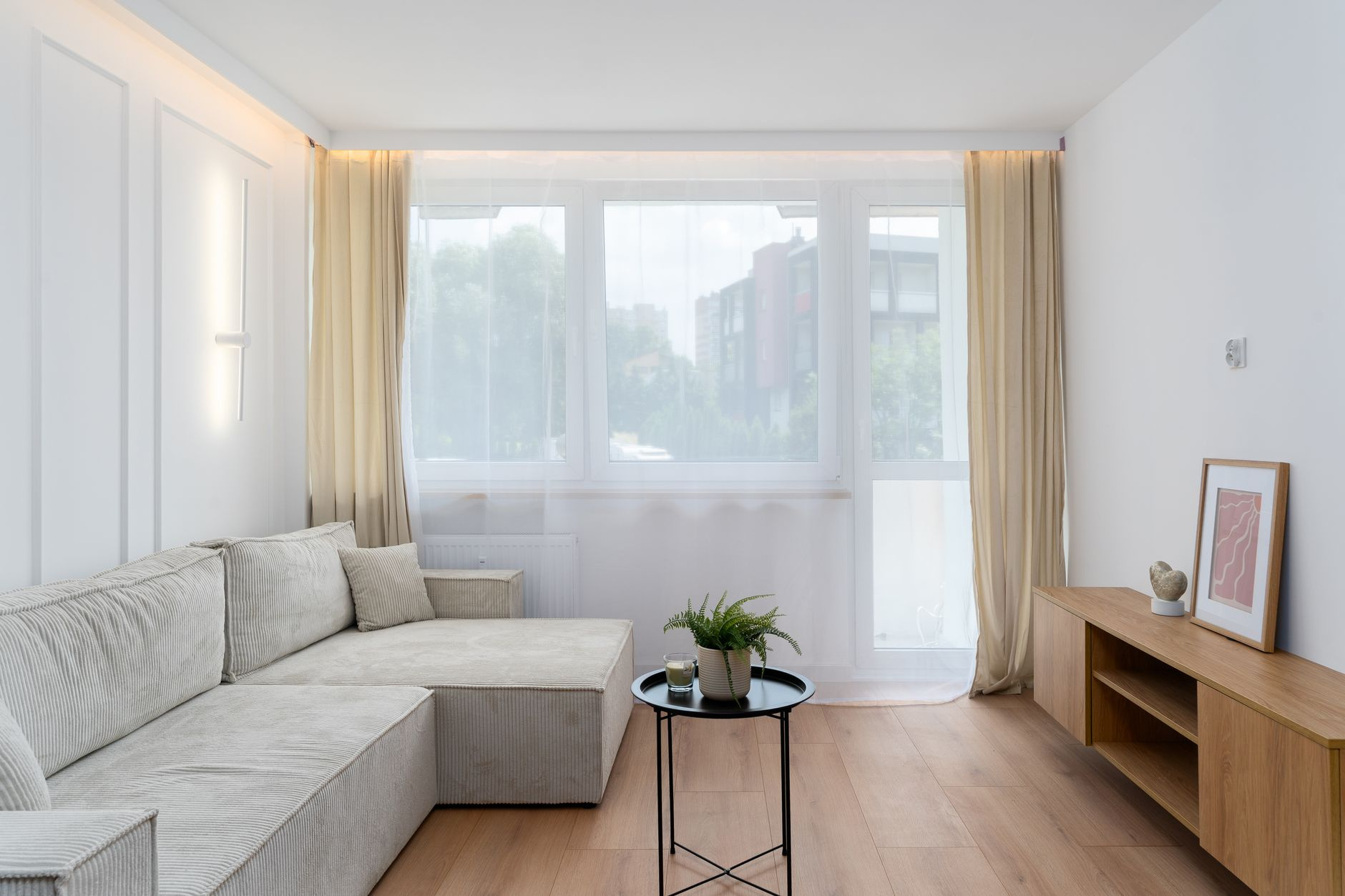 Jasnoszary narożnik w niewielkim minimalistycznym salonie