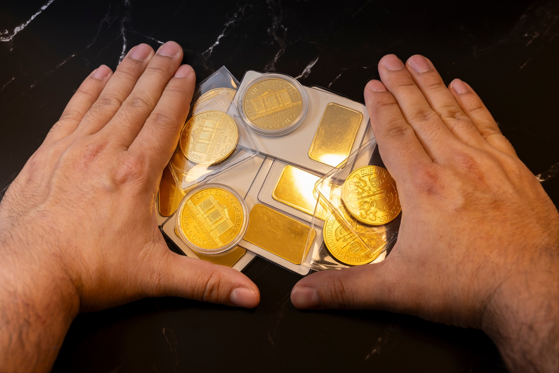 	złote monety okolicznościowe The Royal Mint w oryginalnym opakowaniu kolekcjonerskim oraz małe sztabki złota